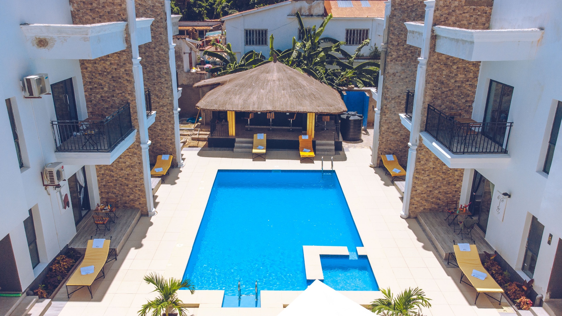MICA Apartments aerial view of pool and thatched bar